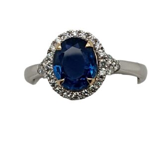 Platinum and 14 Karat Yellow Gold Oval Cut Sapphire and Diamond Halo Ring