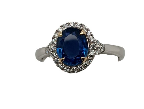 Platinum and 14 Karat Yellow Gold Oval Cut Sapphire and Diamond Halo Ring